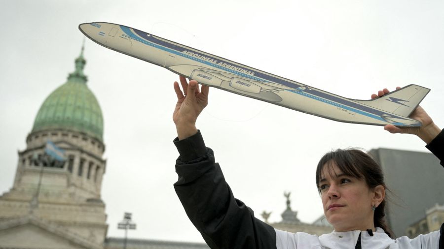 Photogallery A member of the aeronautical unions holds a cardboard airplane to protest against the privatization of the state airline Aerolíneas Argentinas in front of Congress in Buenos Aires