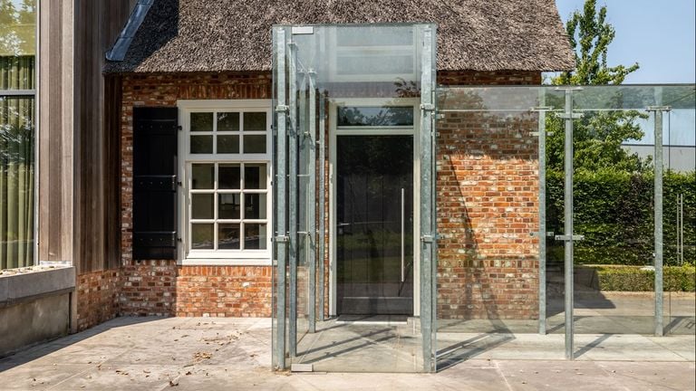 The glass passage from the house to the garage (photo: Van Baarle Makelaardij).