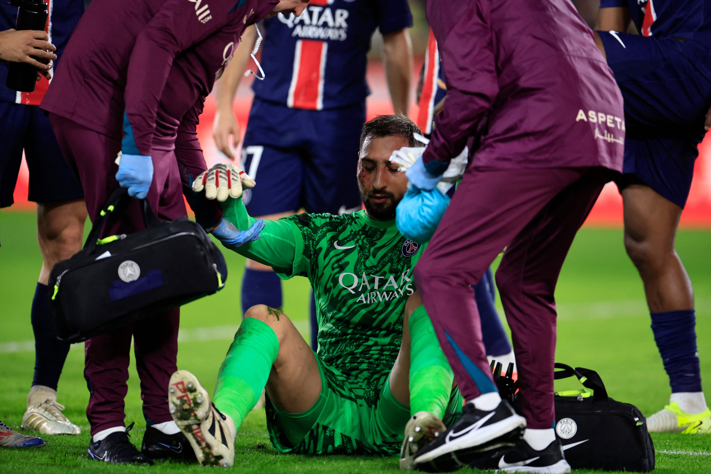 Paris Saint-Germain's Italian goalkeeper #01 Gianluigi Donnarumma receives medical help after sustaining an injury during the French L1 football match between AS Monaco and Paris Saint-Germain at the Louis II Stadium (Stade Louis II) in the Principality of Monaco on December 18, 2024. (Photo by Valery HACHE / AFP)