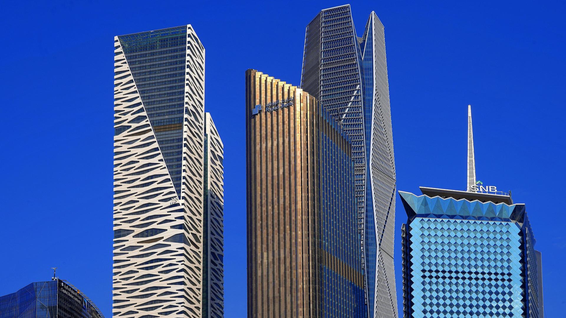 Several glass high-rise towers against a blue sky in Riyadh.
