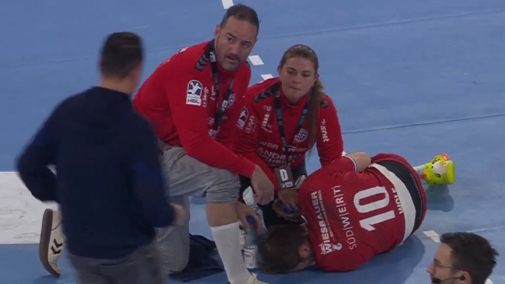 Bietigheim-Trainer Iker Romero (2. v. l.) und zwei Betreuer kümmern sich um Wolf, der sein Gesicht vor Schmerzen im Boden vergräbt