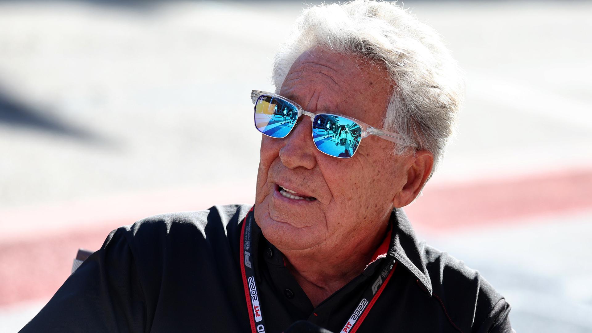 Portrait shot of Mario Andretti with sunglasses.