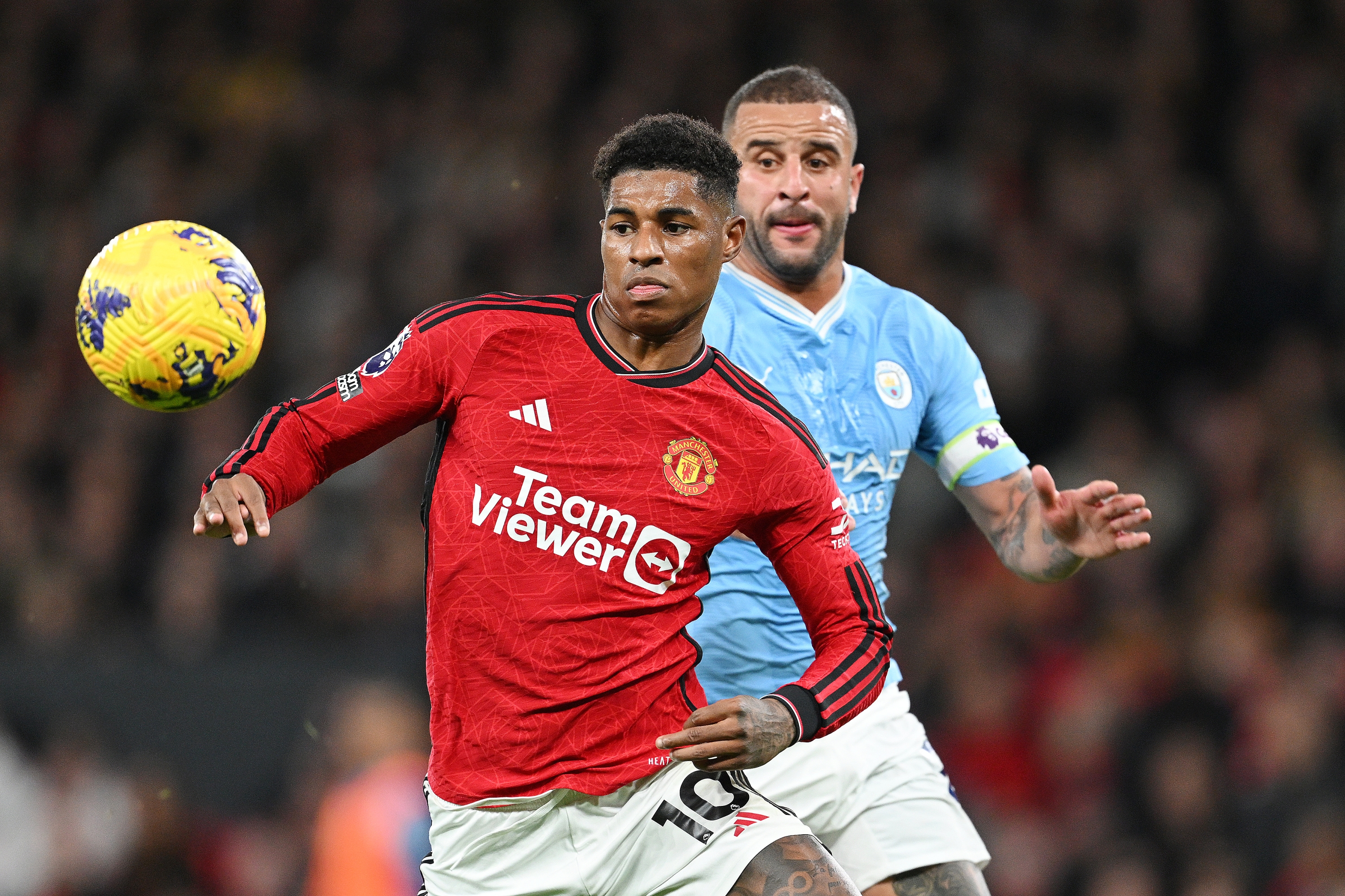 MANCHESTER, ENGLAND - OCTOBER 29: Marcus Rashford of Manchester United is challenged by Kyle Walker of Manchester City during the Premier League match between Manchester United and Manchester City at Old Trafford on October 29, 2023 in Manchester, England. (Photo by Michael Regan/Getty Images)