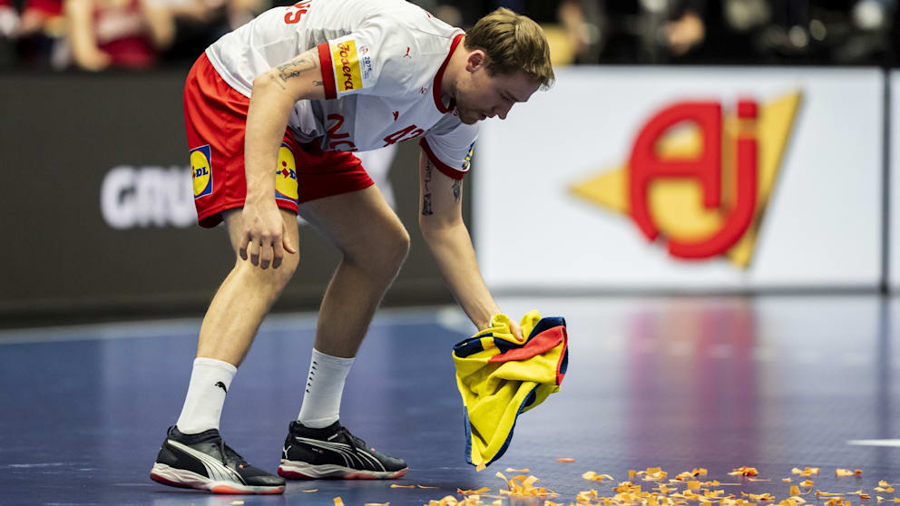 Dänemarks Simon Pytlick wischt mit dem Handtuch die Papier-Schnipsel vom Parkett