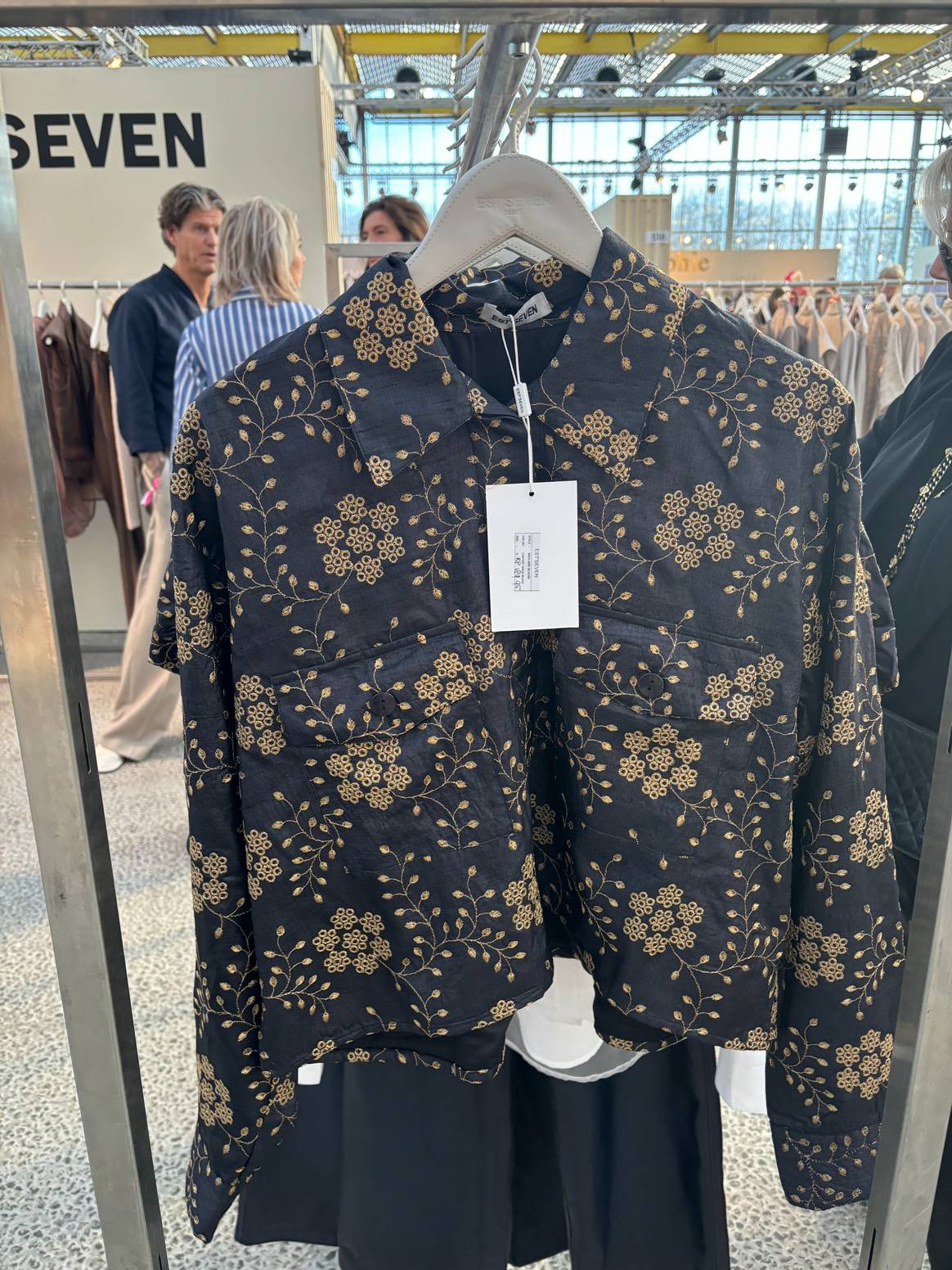 Est seven laat een corte vest zien met gouden borduursels