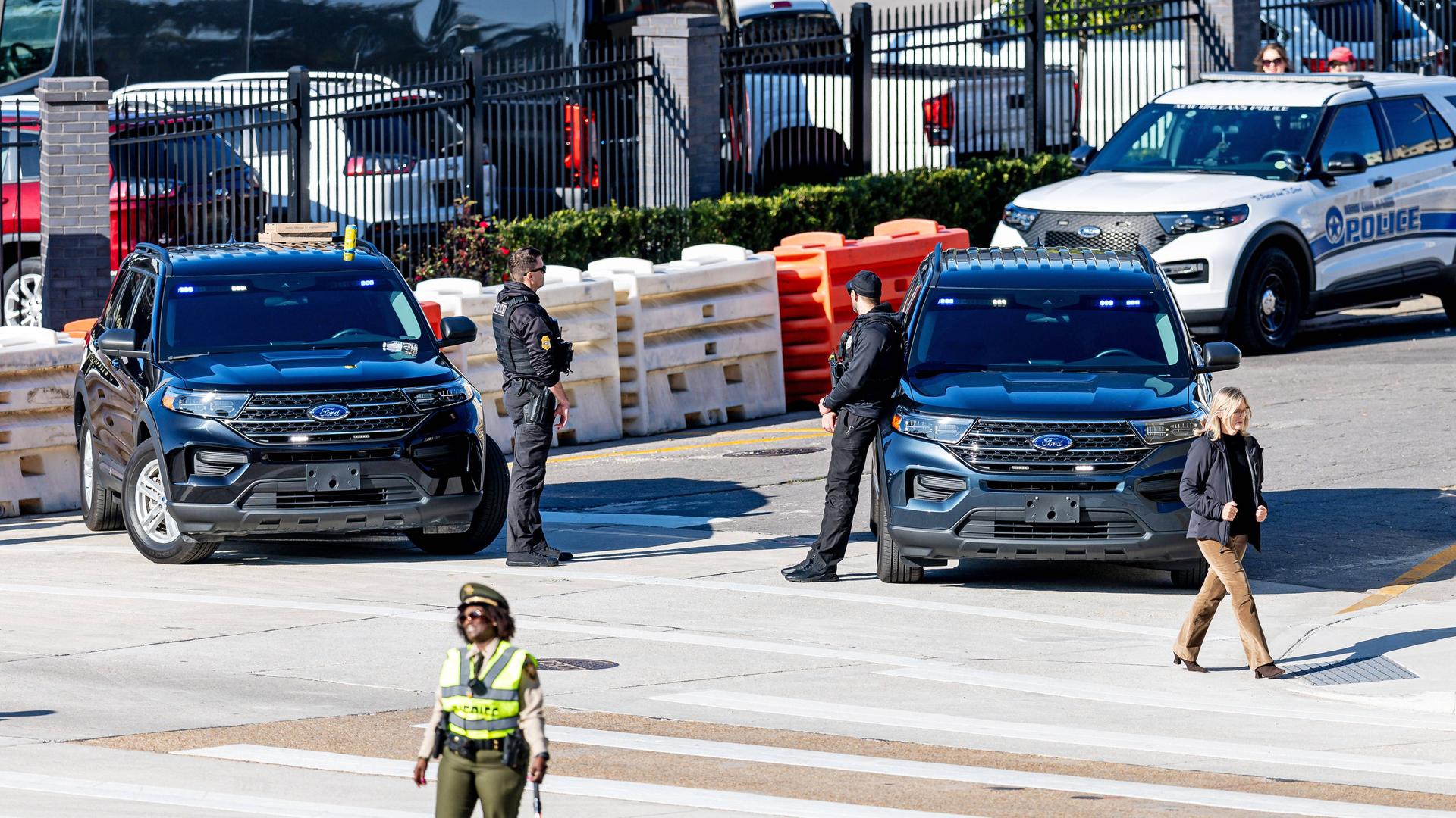 Several police cars block off a street in front of the football stadium in New Orleans.
