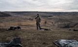 Ukrainian volunteers examine the personal belongings of fallen Russian soldiers on the battlefield in the Donetsk region. 