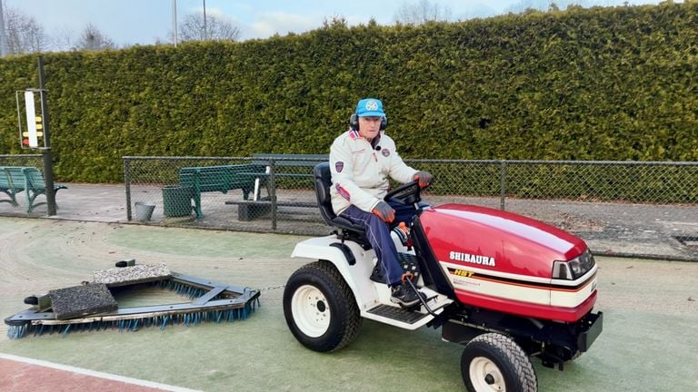Jacques brushes the tennis court clean (photo: Jan Peels).