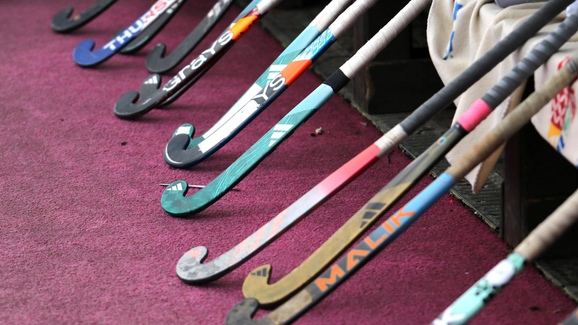 Hockey bats lean on a bank while the team is warm.