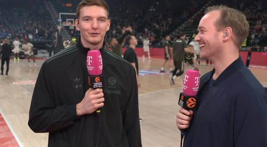 Justus Hollatz wendet sich der Kamera zu und richtet herzliche Worte an seine Oma. Magenta-Sport-Reporter Jan Lüdeke muss herzlich lachen