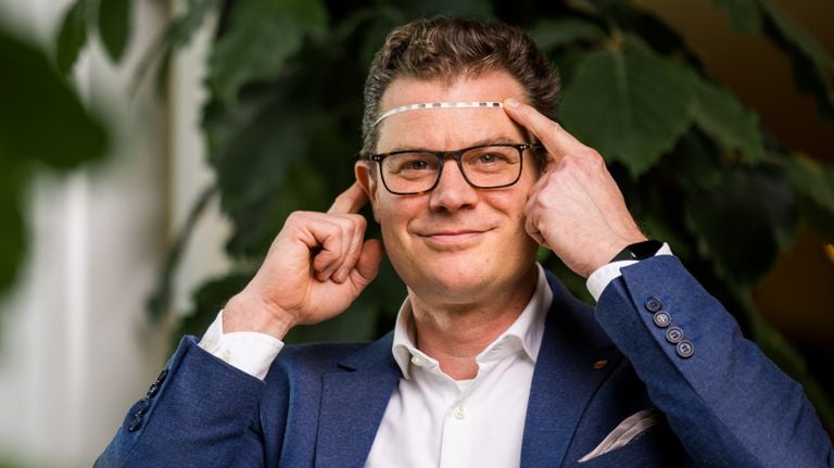 Hubert Martens shows the strip that is implanted in the forehead under the skin (photo: Salvia Bioelectronics).
