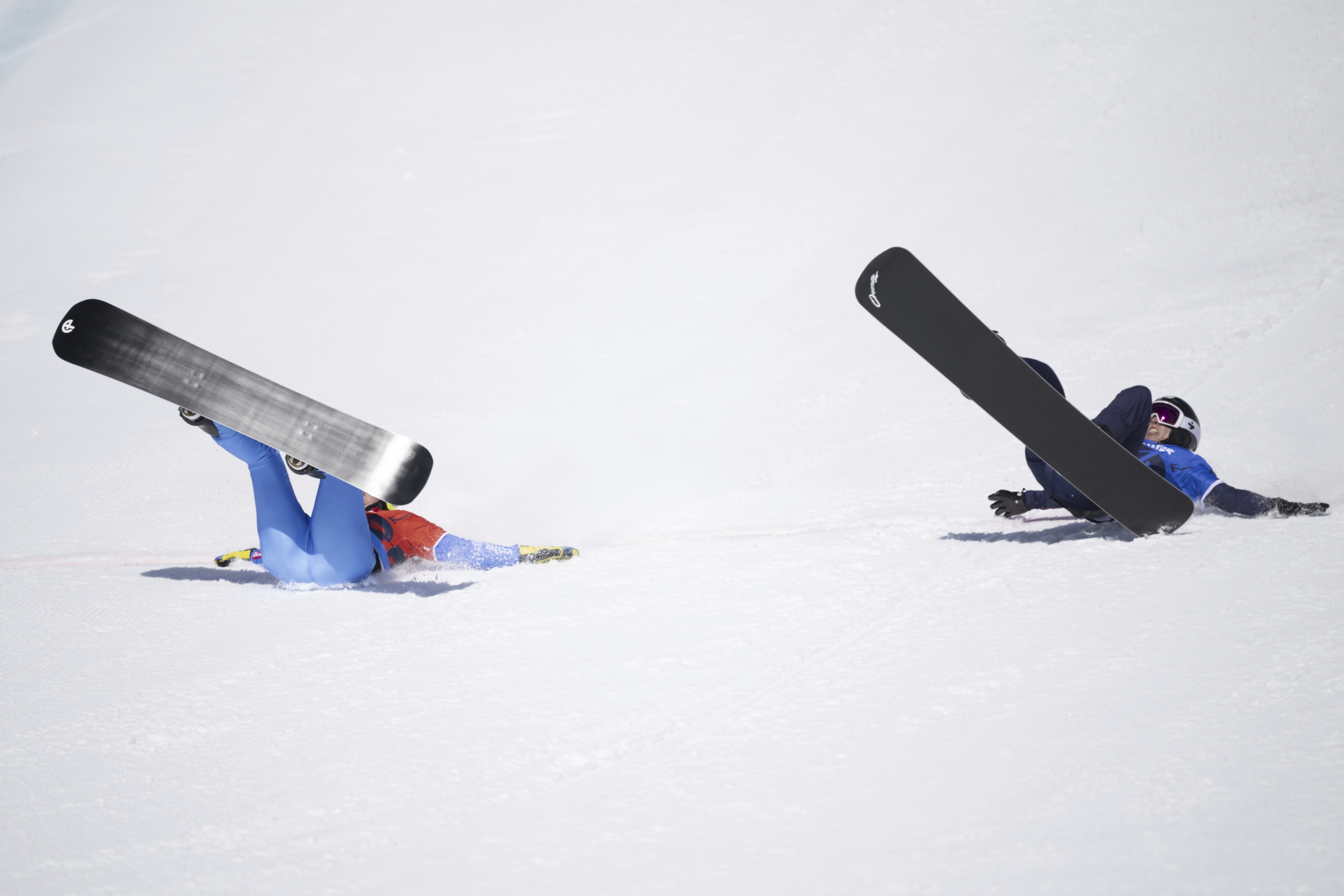 Winner Michela Moioli of Italy, Left, and Second Placed Charlotte Bankes of Britain Cross the Finish Lin in the Snowboardcross Competition at the fis snowboard, freestyle and freeski World Championships on Friday, March 28, 2025, in St. Moritz, Switzerland. (Gian Ehrenzeller/Keystone via AP)