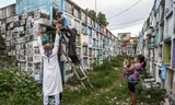 'Father Flavie' (Left) helps in July 2021 to move the remains of the shot Rodzon Enriquez.