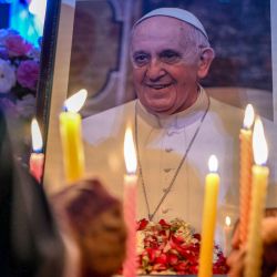 People turn on candles to pay tribute to a portrait of Pope Francis during a condolences encounter in New Delhi, after the news of his death. Pope Francis, an energetic reformer who inspired great devotion among Catholics, but irritated the traditionalists, died on April 21 at age 88, just one day after greeting the delightful faithful after the Easter Mass. | Photo: Sajad Hussain / AFP