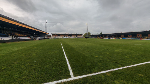 The empty Cledara Abbey Road Stadium of Cambridge United © Lennart Fey - The empty Cledara Abbey Road Stadium of Cambridge United, 3 stands can be seen, as well as the lawn. The photo is scored from the perspective next to one of the goals. The club letters Cufc are on the back tribpne. The sky is gray and cloudy.