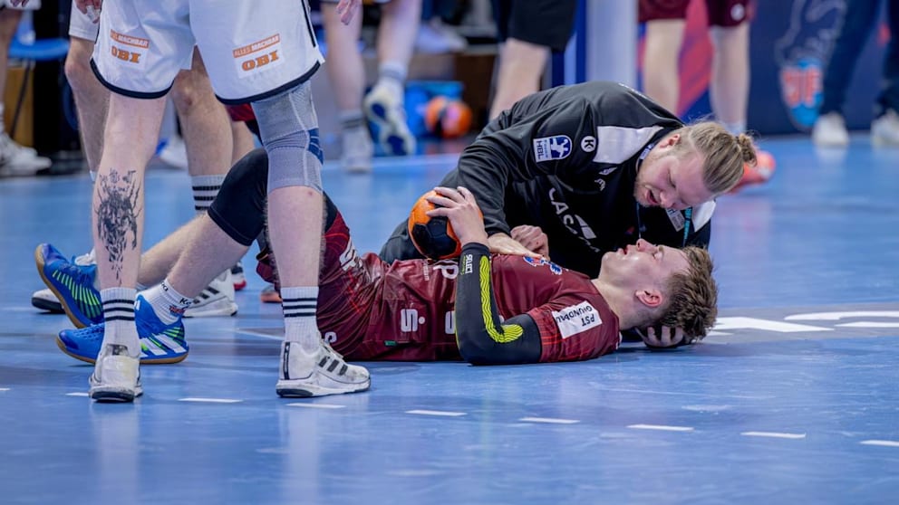 Nicolas Paulnsteiner (20) nach dem Zusammenstoß, wird vom Potsdamer Physio Jonas Friedrich behandelt