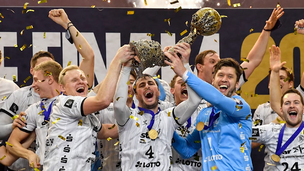 Wiencek hält mit Domagoj Duvnjak und Torwart Niklas ­Landin den Champions-League-Pokal hoch. Im Finale 2020 schlug Kiel Barcelona 33:28
