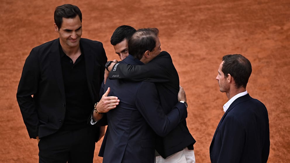 Rafael Nadal umarmt Novak Djokovic. Roger Federer (l.) und Andy Murray schauen zu