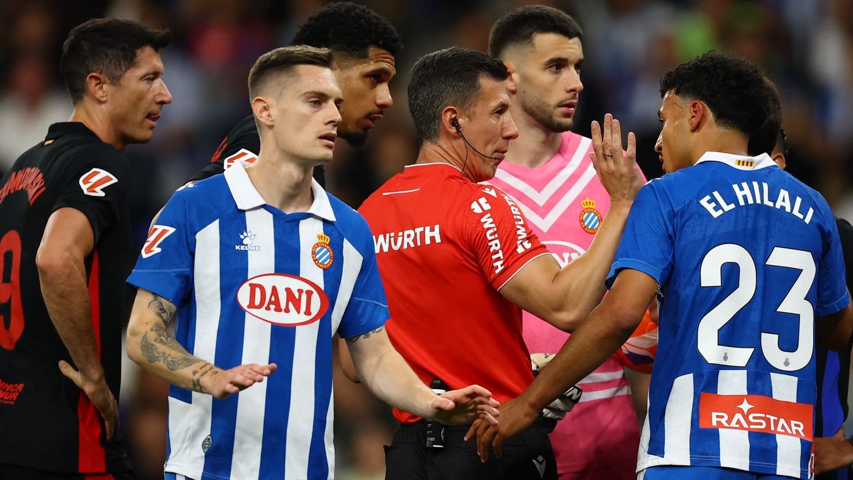 Concerned looks: Players of Espanyol and Barça surround referees Soto. Concerned looks: Players of Espanyol and Barça surround referees Soto.