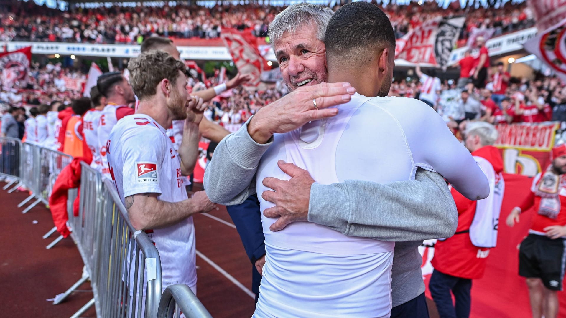 The new coach Friedhelm Funkel hugs Linton Maina after the away win.