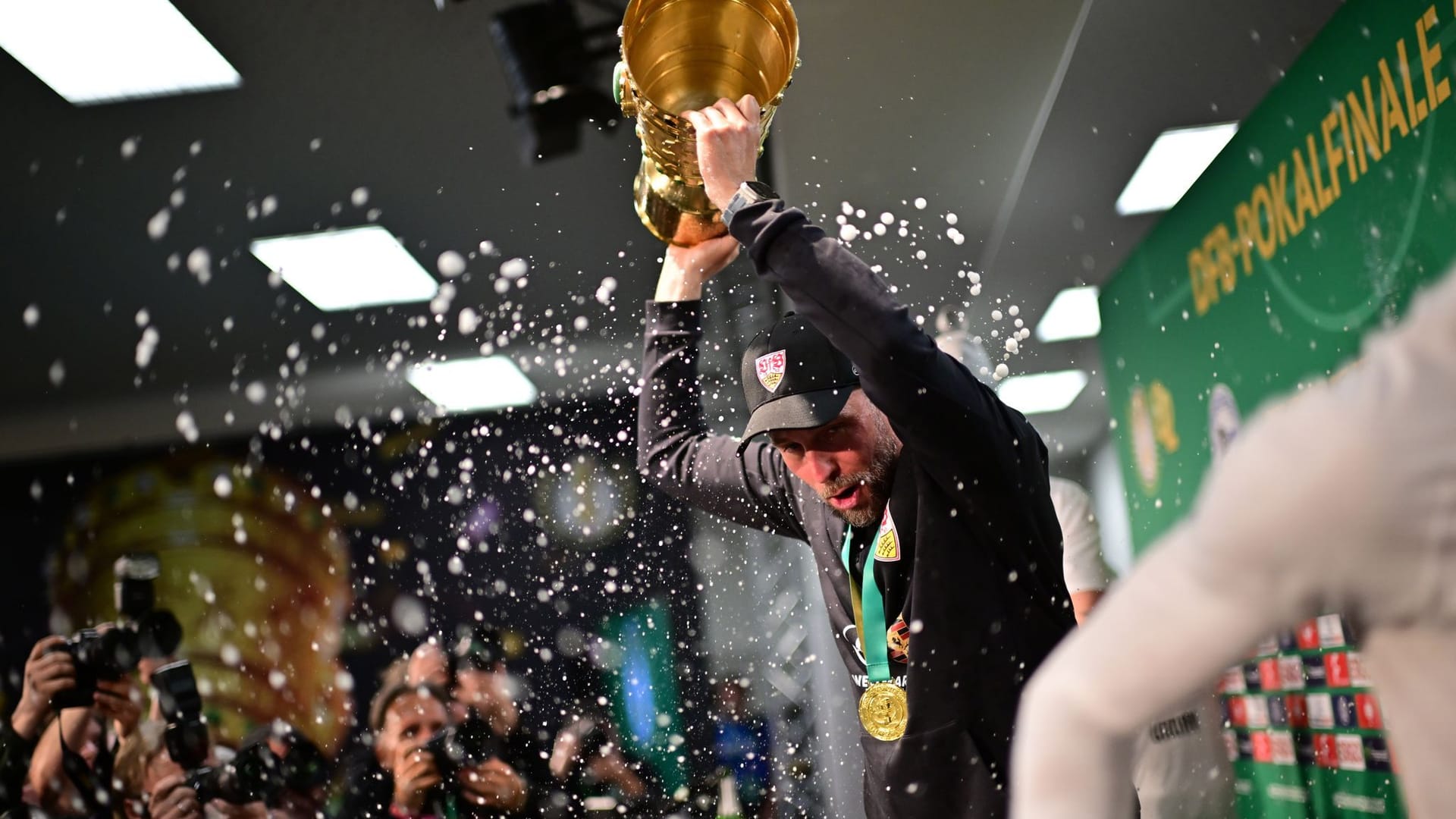 Stuttgart coach Sebastian Hoeneß gets a beer shower during the press conference.