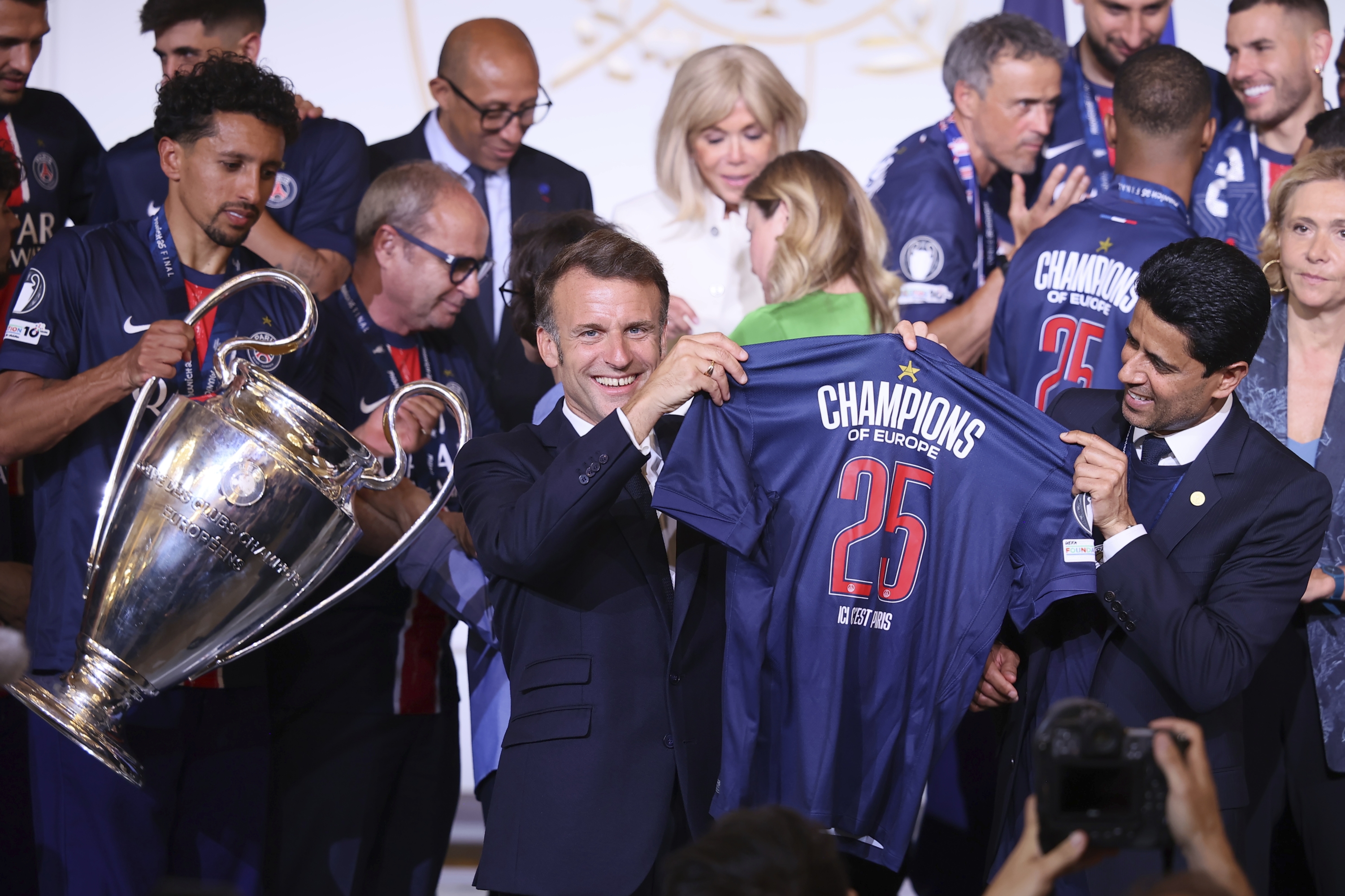 French president Emmanuel Macron, Left Center, Holds a PSG Jersey 
