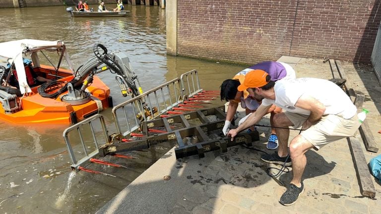 Alderman Jeroen Bruijns and director Birgitte van Beurden drag a fence out of the water (photo: Ronald Sträter).