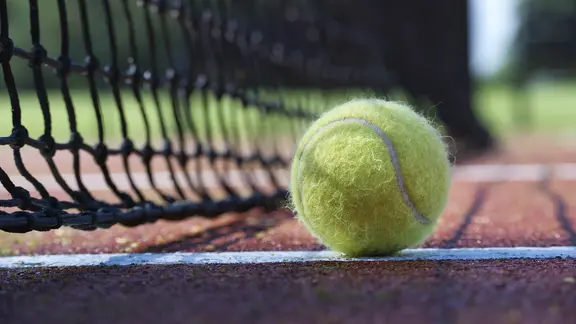 A tennis ball is on the net