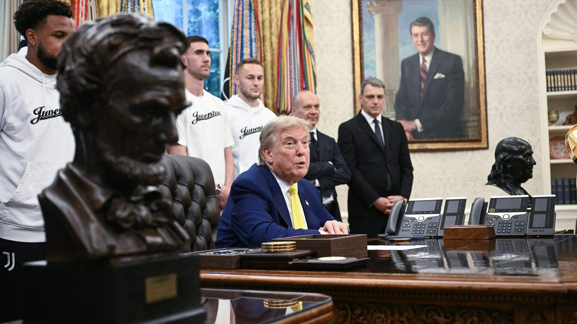 Donald Trump talks, Teun Koopmeiners listens in the background.