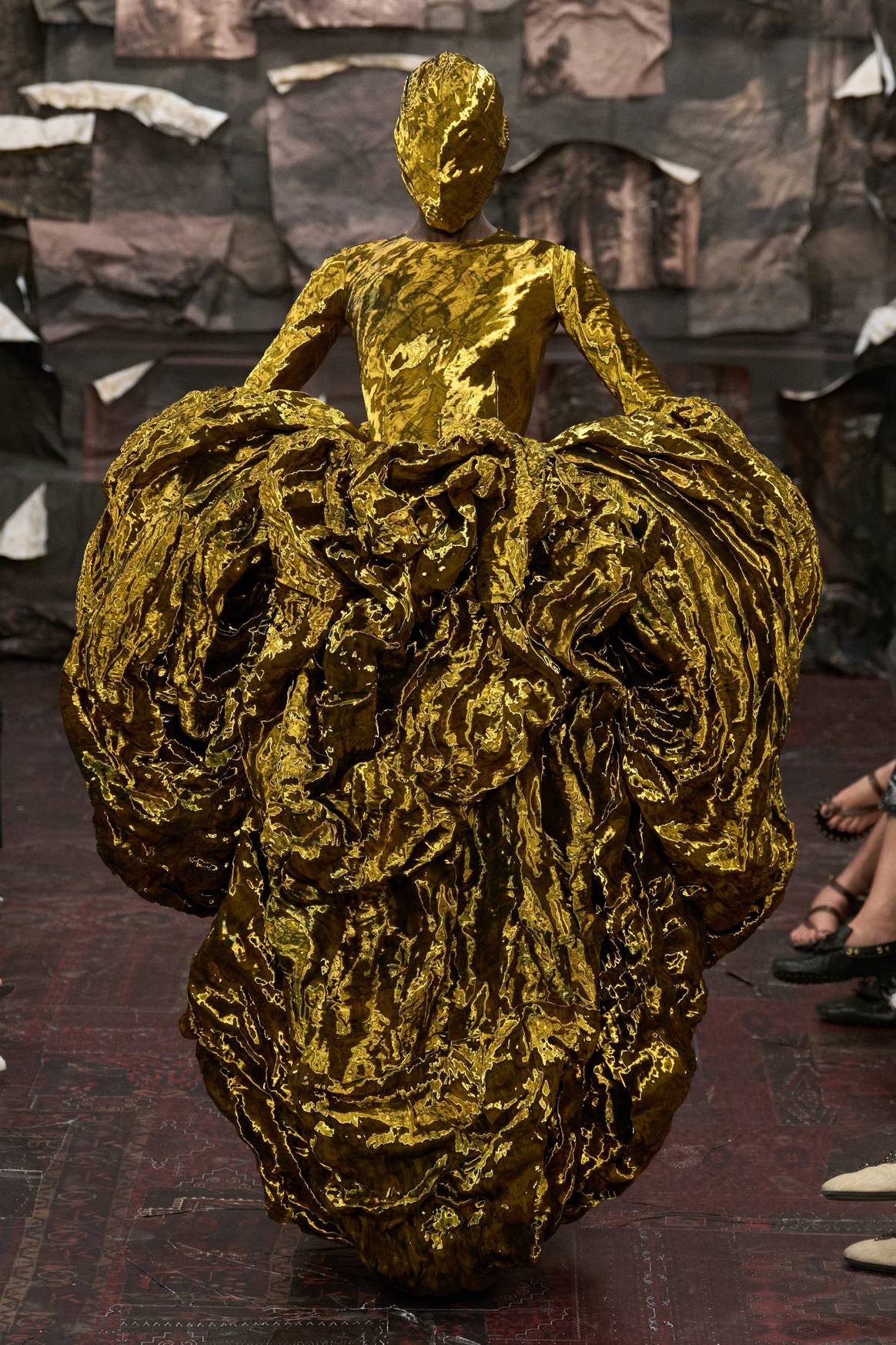 Look 10: A dress with a draped, heart -shaped skirt made of golden fabric, with metal threads.