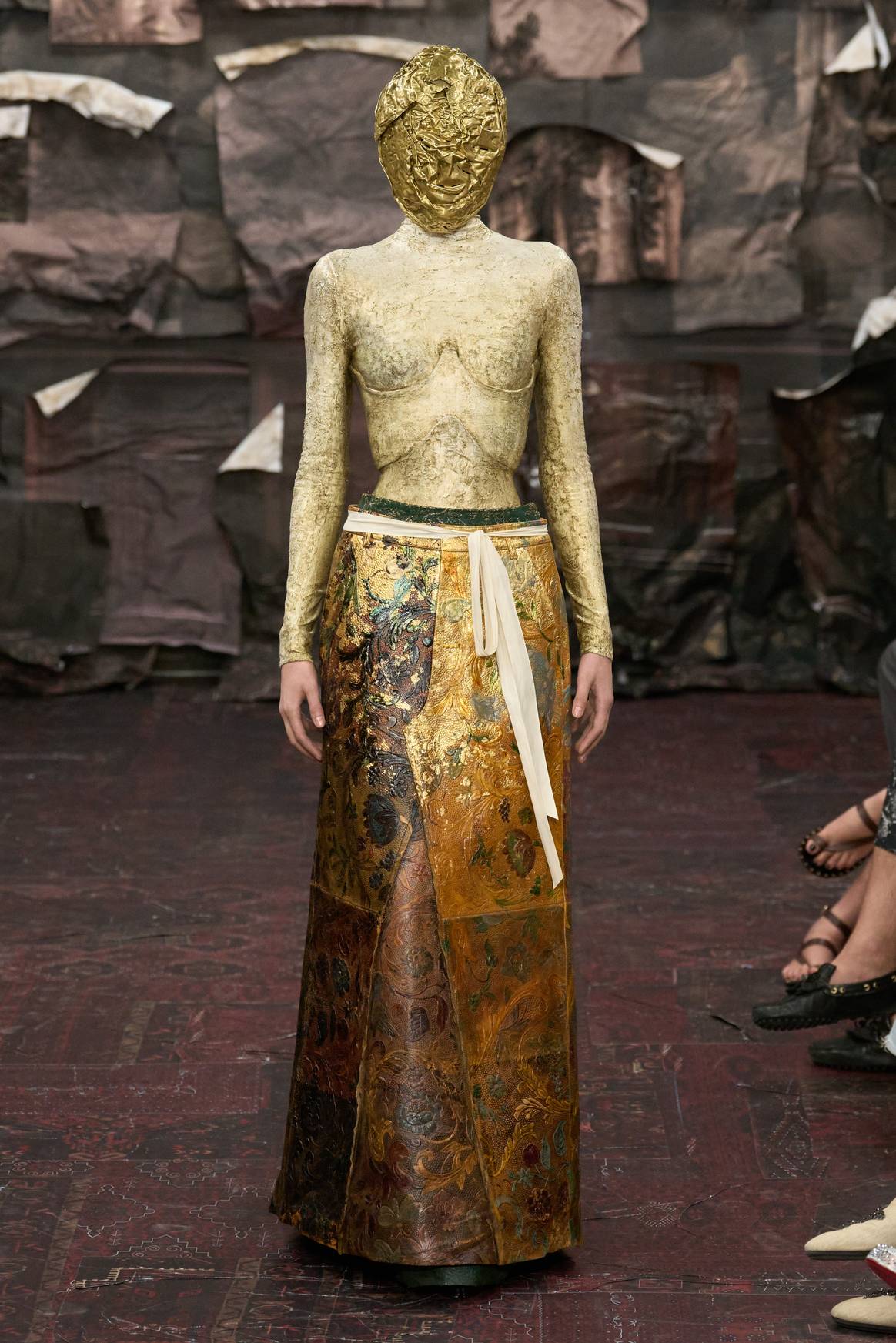Look 13: Corset with an undercress and apron made of leather pants, hand -painted and decorated with gold leaf.