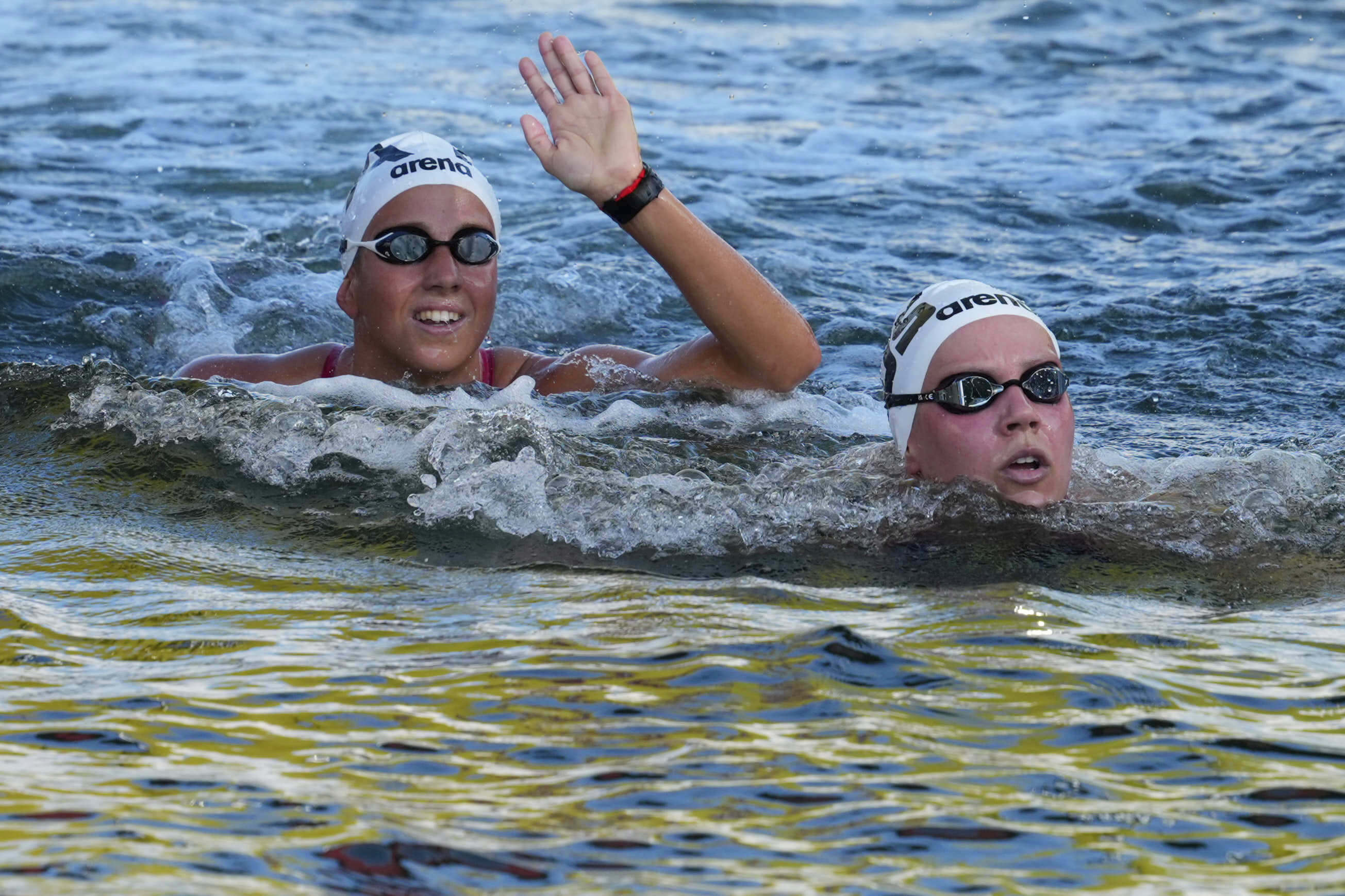 First Place Winner Moesha Johnson of Australia, Right, and Second Place Winner Geneva Taddeucci of Italy React After The Women's 5km Open Water Final at the World Aquatics Championships in Singapore, Friday, July 18, 2025. (AP Photo/Vincent Thian)