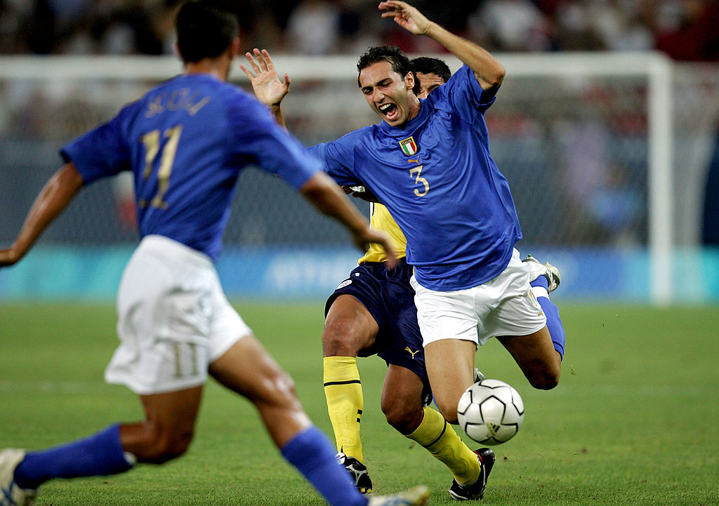 Athens - August 18: Emiliano Moretti #3 of Italy is tackled by a Player from Paraguay in the Men's Football Preliminary Match on August 18, 2004 During the Athens 2004 Summer Olympic Games at Karaiskaki Stadium in Athens, Greece. (Photo by Andy Lyons/Getty Images) *** Local Caption *** Emiliano Moretti