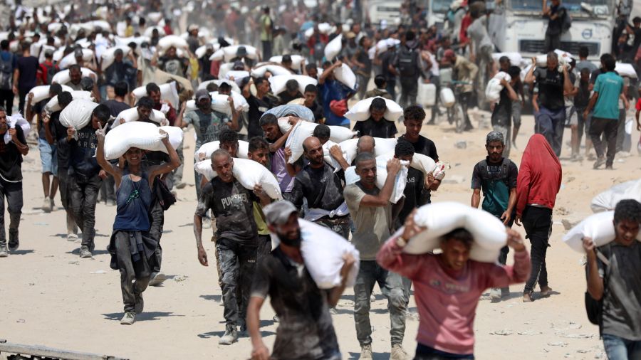 PHOTALERIA Image of Palestinians carrying bags of flour after humanitarian aid entered Gaza through a border crossing, in Beit Lahia, in the north of the Gaza Strip.