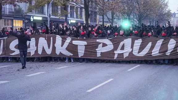 Fans of FC St. Pauli with banners on the way to the Hamburg city derby on December 1, 2023.