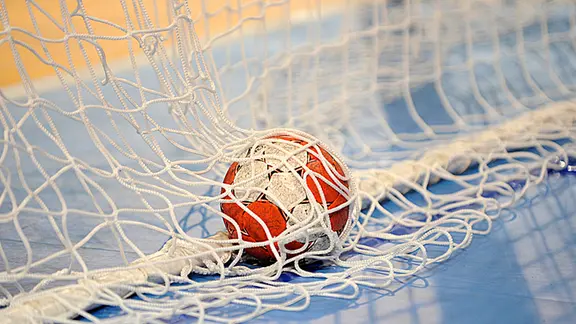 A handball is in the goal net.