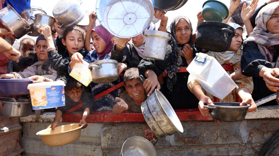 Palestinian photo gallery congregate at a lentil soup distribution point in the city of Gaza, north of the Gaza Strip
