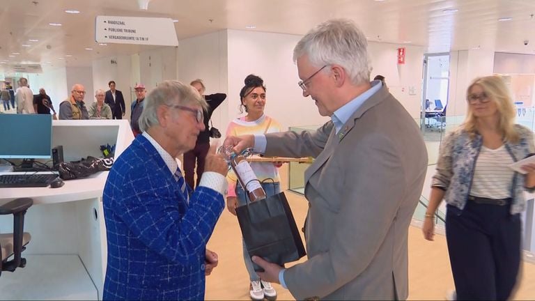 Weterings receives scrubbelèr from a resident (photo: Omroep Brabant) ..