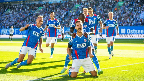 Rostock's Marco Schuster (front) and his teammates cheer a goal.