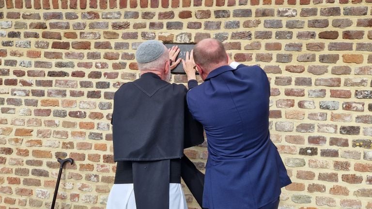 Brother Edgard Claes sets the last stone (photo: Tom Berkers).