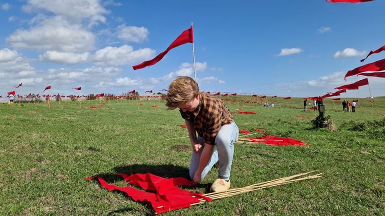 Réan Gerritsen (18) at work to get the flags into the ground (photo: Tom Berkers).
