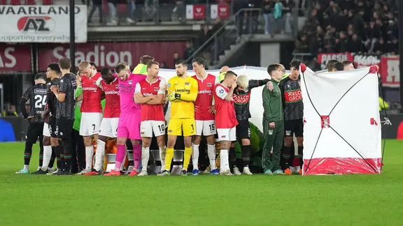 The players of NEC Nijmegen and Az Alkmaar stand around the former Wolfsburg Bas Dost, who was collapsed.