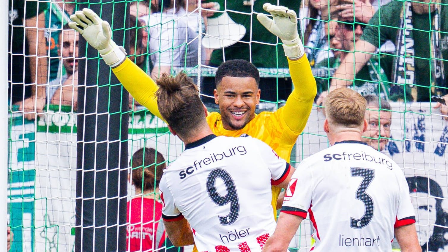 Unhangeable: Freiburg goalkeeper Atubolu is celebrated by his teammates after the elf held against Bremen.