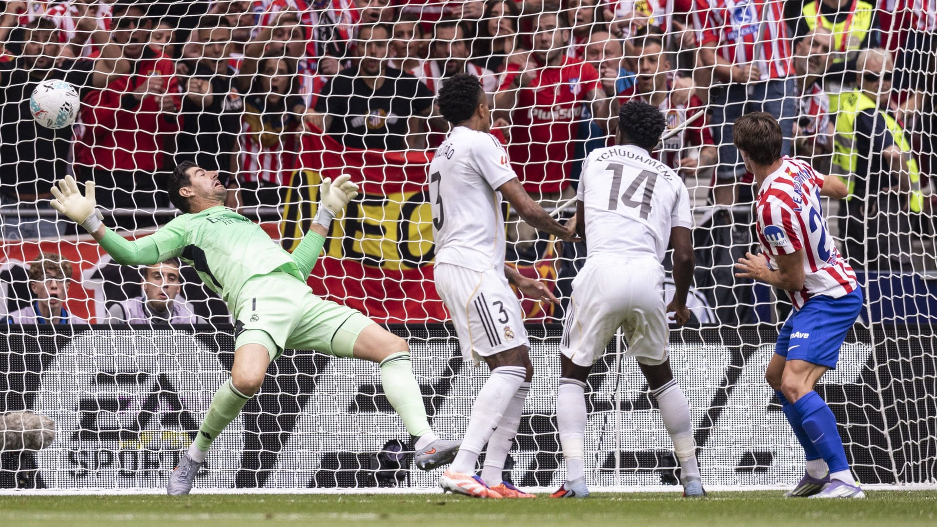 Considered: Atléticos Le Normand (right) heads, real goalkeeper Courtois is powerless.