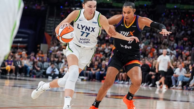 Minnesota Lynx striker Maria Kliundikova (77) dribbles past Phoenix Mercury striker Satou Sabally (0).
