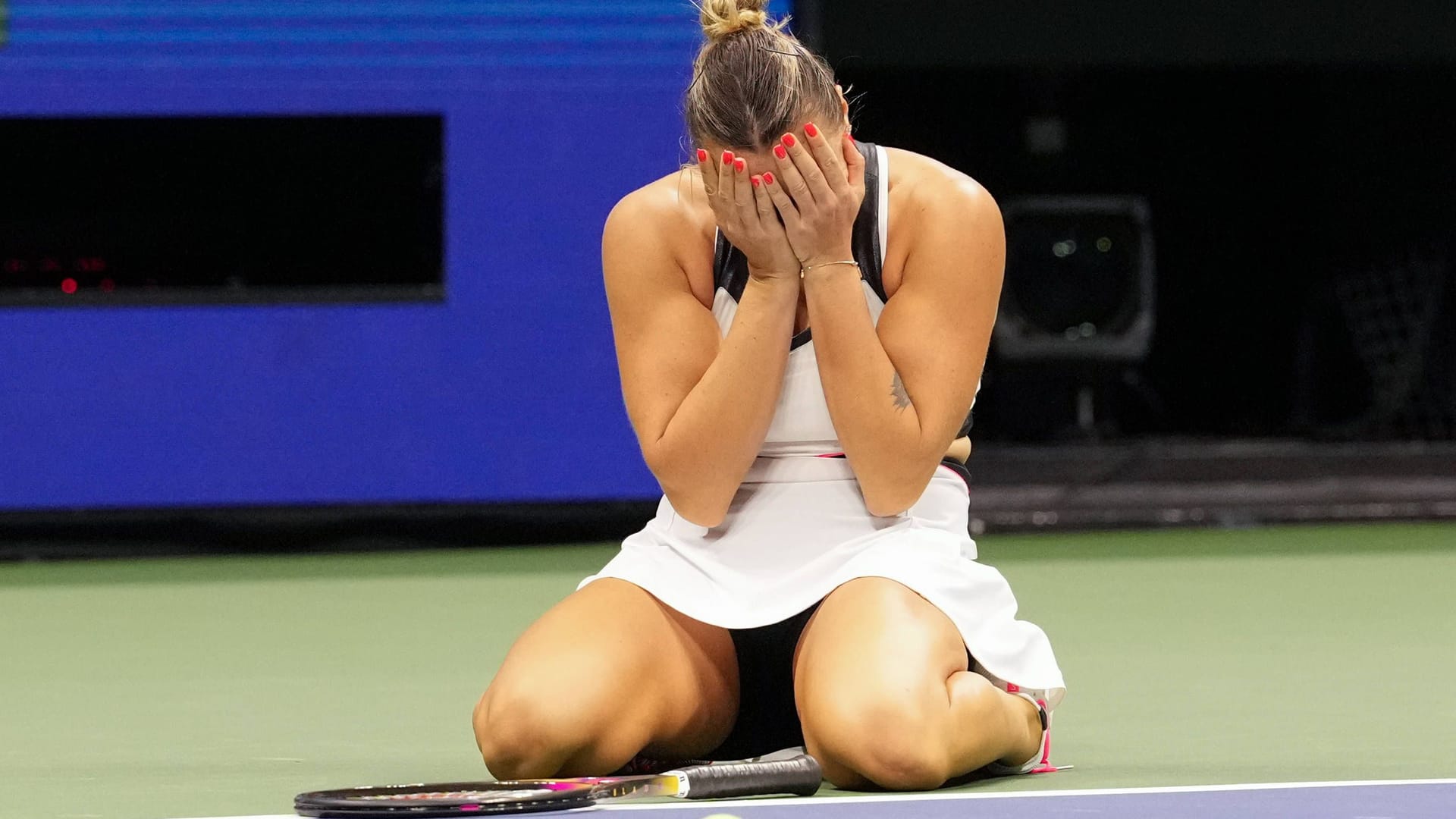 At the goal: Aryna Sabalenka sinks to the ground after the match ball against Amanda Anisimova.
