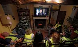 Members of the yellow vest movement watch French President Emmanuel Macron's speech earlier this month in which he announced various purchasing power measures.
