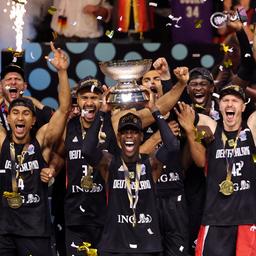Dennis Schröder holds up the European Championship title and celebrates with his teammates