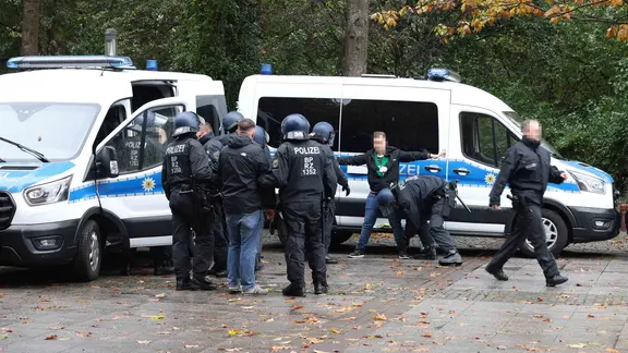 Police officers check a football fan