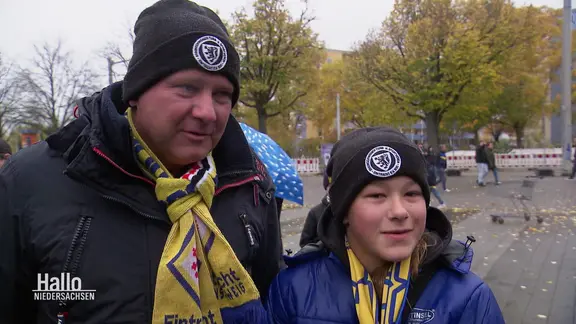 Father and daughter with Eintracht Braunschweig fan scarves in an interview